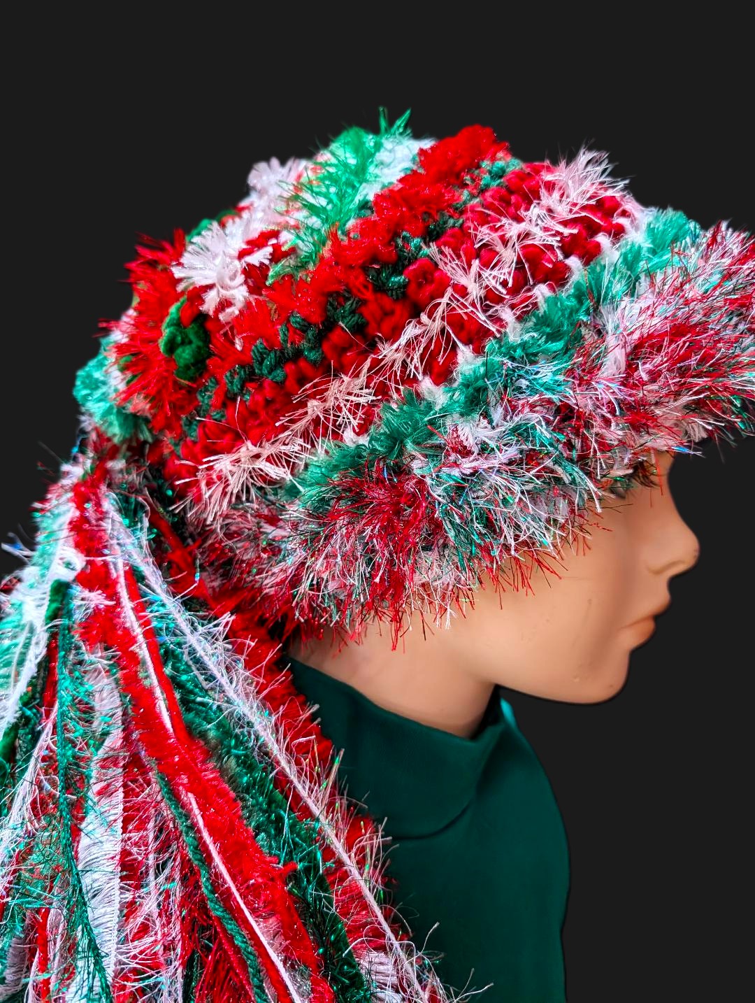 Bright Red, White, Green Christmas Hat with Sparkle, Texture, Fur & Long Tail Fringe. Close-up View of Hat Crown.