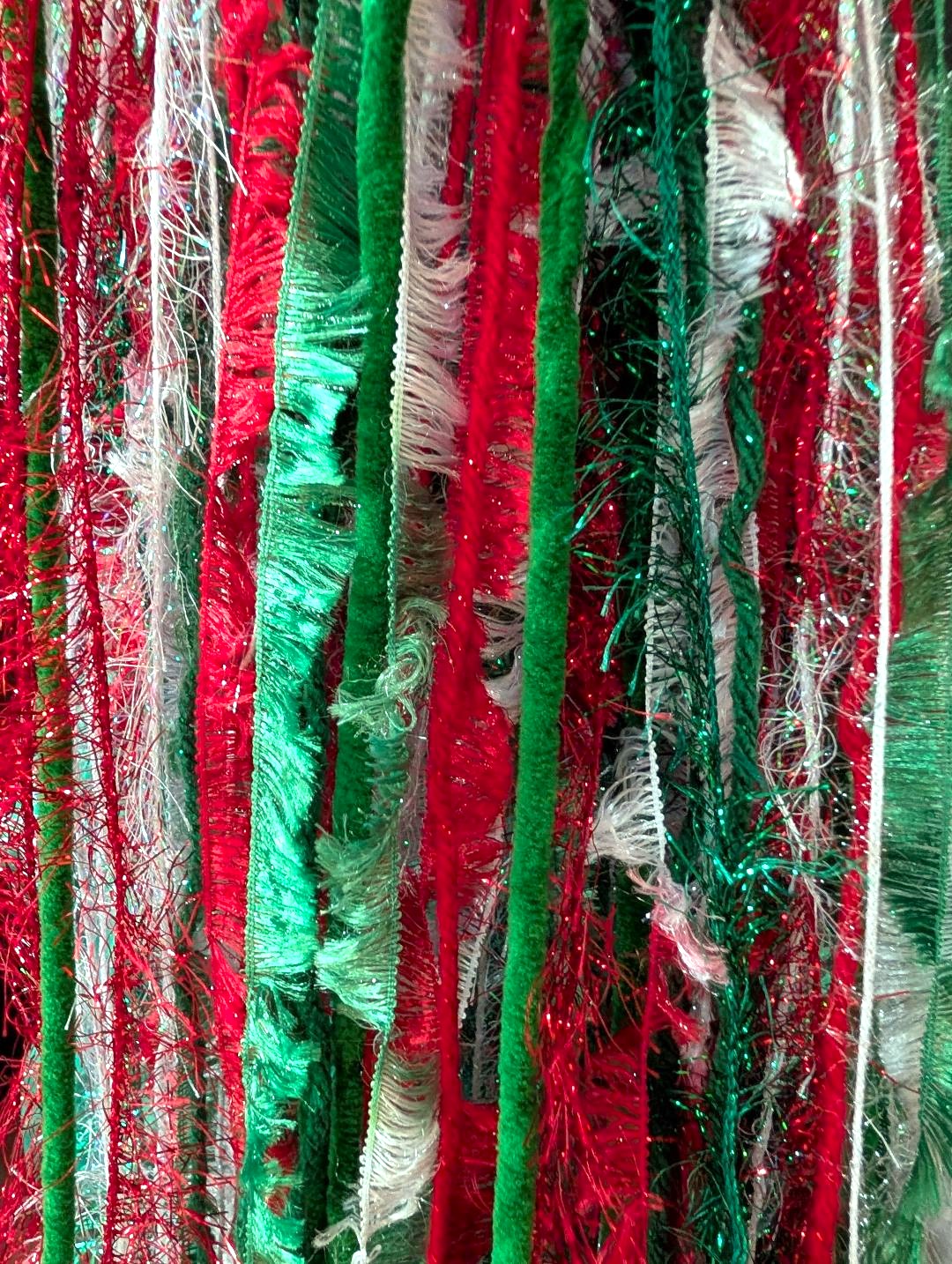 Bright Red, White, Green Christmas Hat with Sparkle, Texture, Fur & Long Tail Fringe. Close-up View of Long Fringed Tail.
