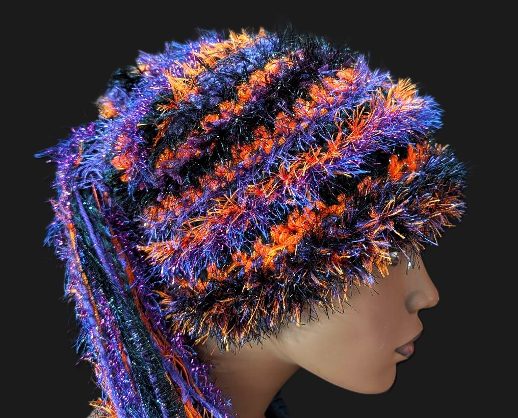 Black, Purple & Orange Halloween Hat with Sparkle, Texture, Fur & Long Tail Fringe. Close-up of Crown showing yarn, texture and stitch detail.