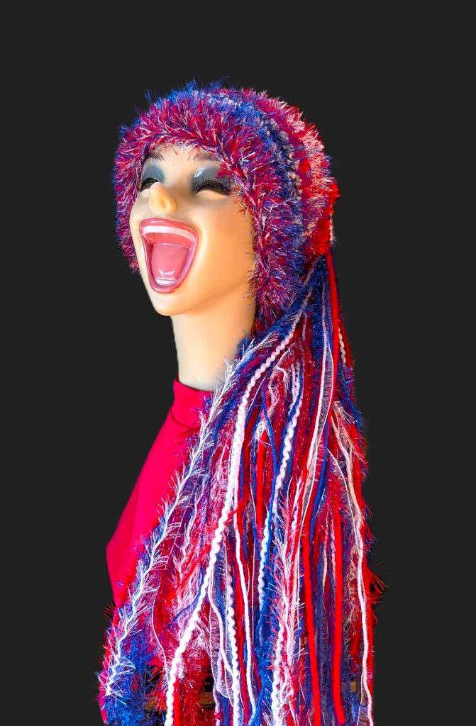 Bright Red, White & Blue Slouchy Beanie Hat with Sparkle, Texture, Fur & Long Tail Fringe. Corner View showing Head & Torso with Full Hat Length.